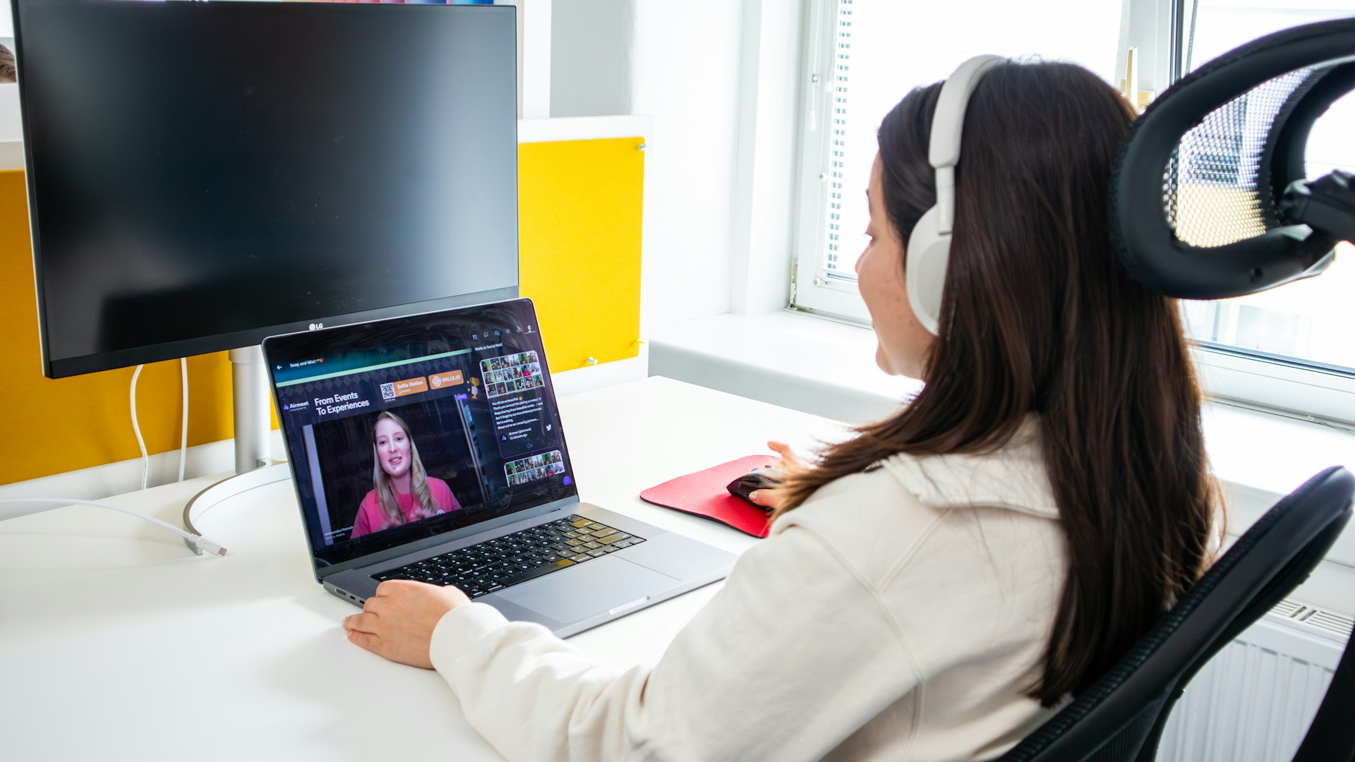 a woman sitting at a desk with a laptop and headphones